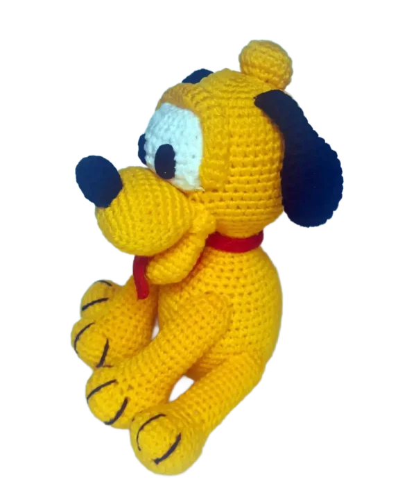 Vista izquierda del amigurumi de Baby Pluto, destacando su postura sentada y detalles del cuerpo tejido a mano.
