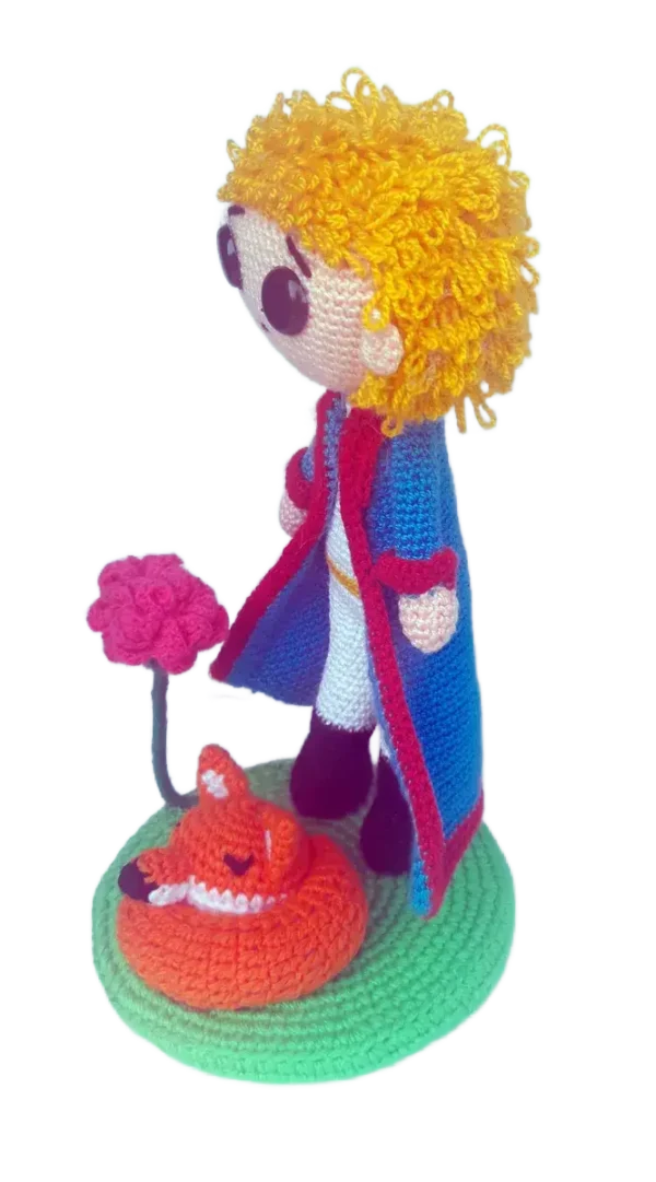 Muñeco artesanal de El Principito estilo amigurumi, con detalles bordados y ropa colorida.