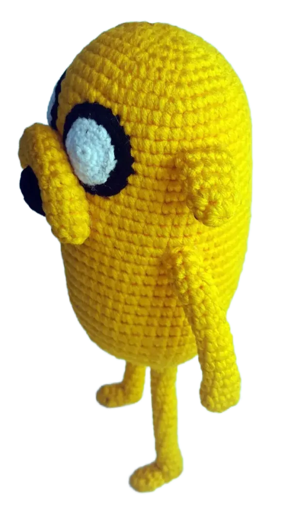 Jake el Perro amigurumi sobre fondo blanco, tejido a mano con detalles cuidados.