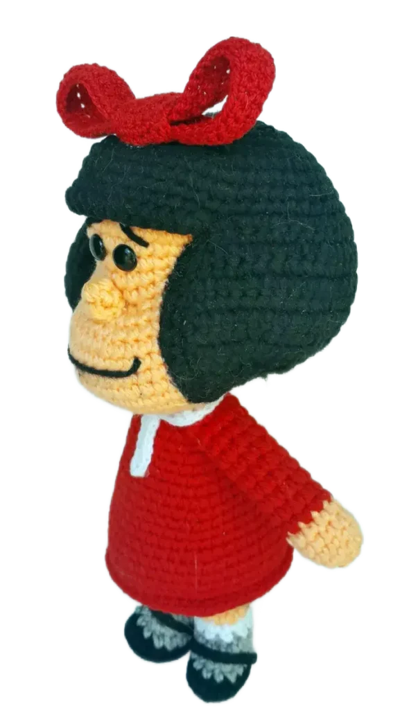 Perfil de Mafalda amigurumi, mostrando su cabello negro voluminoso y detalles del vestido desde el costado.