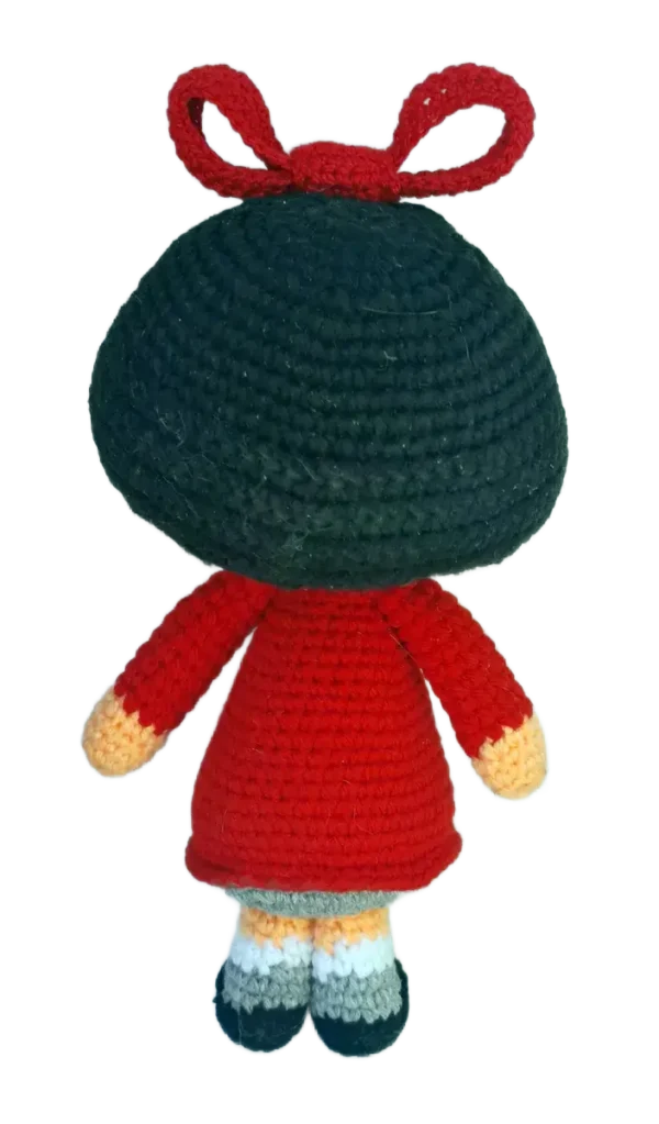 Parte trasera del muñeco amigurumi de Mafalda, mostrando su peinado redondeado y el cierre del vestido tejido.