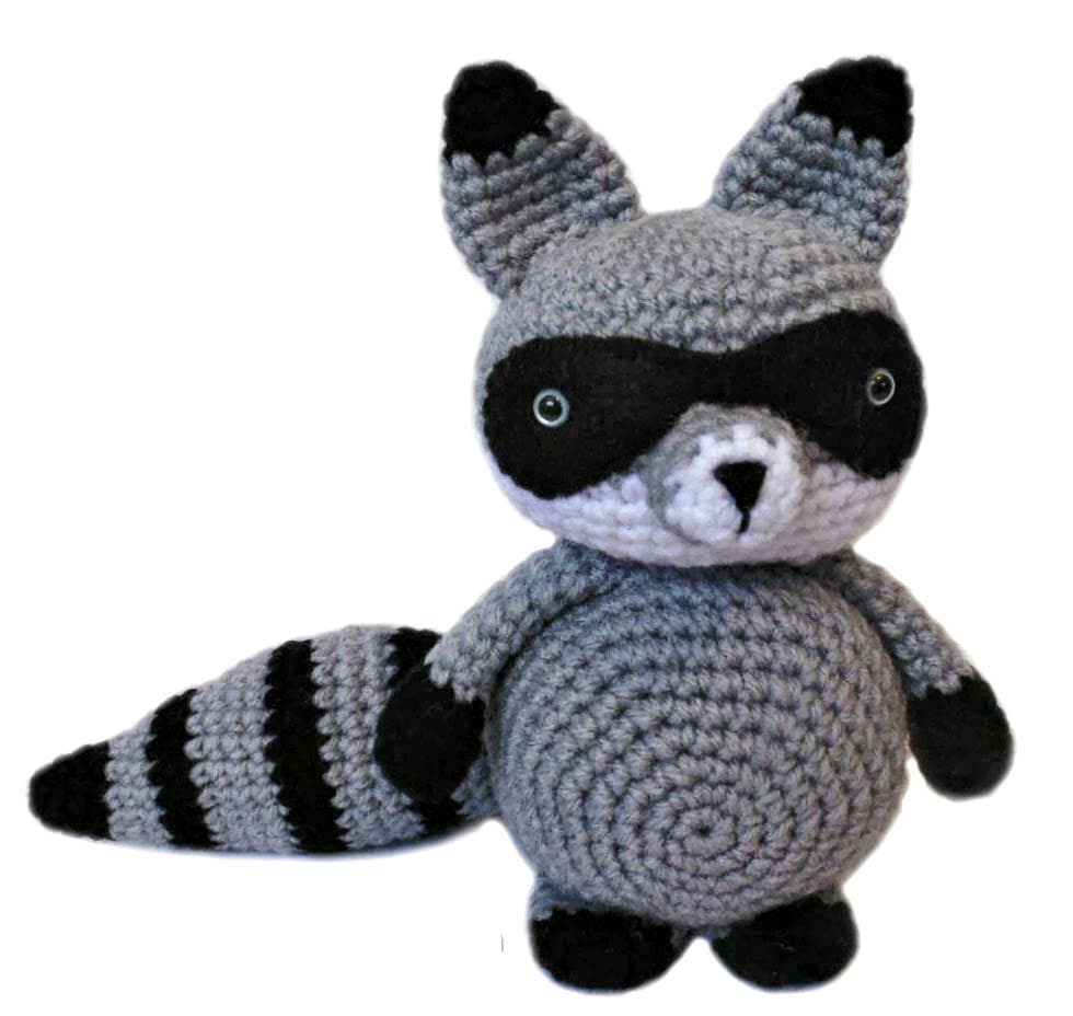 Mapache amigurumi tejido a crochet, de pie, con detalles en gris, blanco y negro, ideal como muñeco de apego o decoración infantil