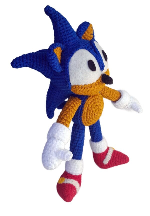 Primer plano del rostro del amigurumi de Sonic tejido a crochet, mostrando sus ojos bordados y expresión clásica del personaje.
