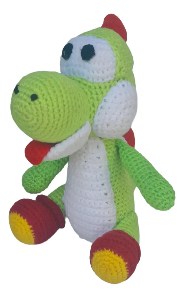 Muñeco Yoshi amigurumi tejido a crochet con lana verde y blanca sobre fondo blanco.