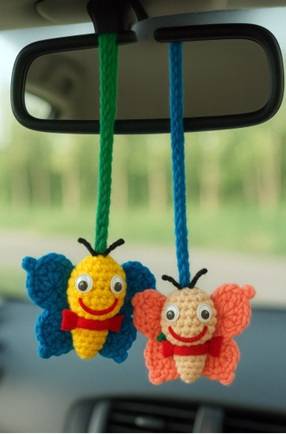 mariposas amigurumi colgando del espejo retrovisor de un automovil