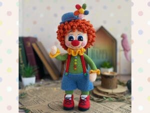 payaso amigurumi muy colorido sobre una mesa con taza de cafe