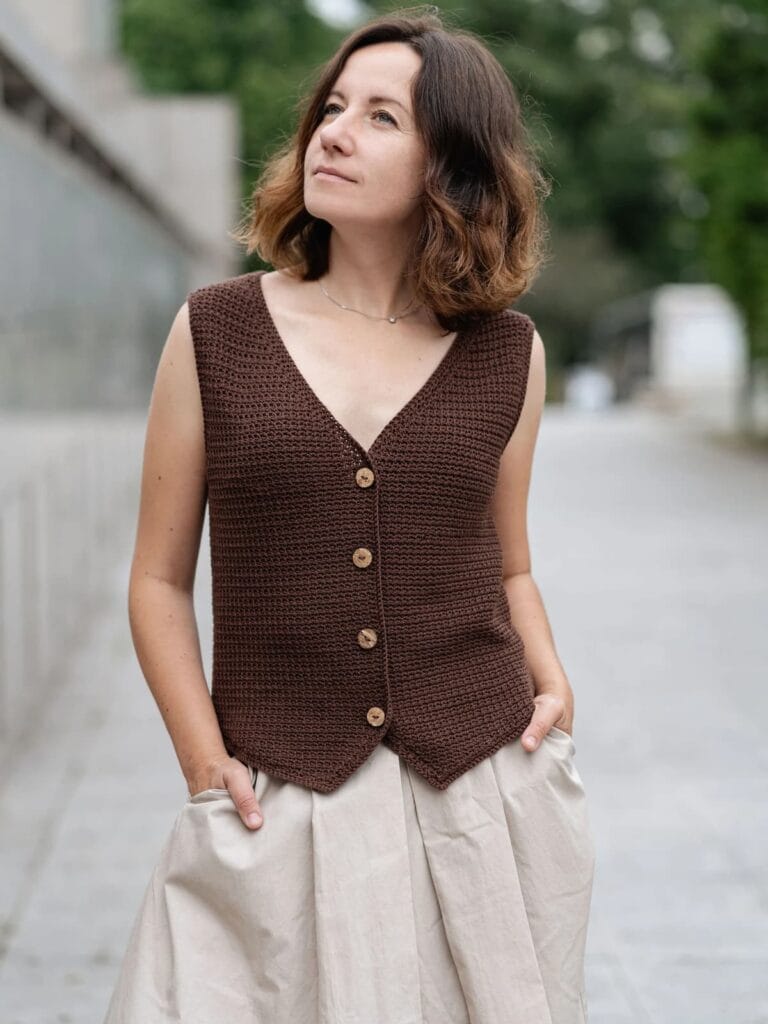 Chaleco artesanal tejido a crochet en color marrón con botones de madera, prenda sin mangas y escote en V, ideal para combinar con faldas o pantalones.