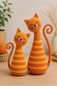 Amigurumi cat for beginners, orange tabby style, crocheted with tilted head and spiral tail.