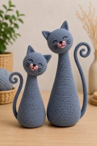 Amigurumi cat for beginners, Russian blue style, crocheted with tilted head and spiral tail.