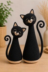 Amigurumi cat for beginners, black style, crocheted with tilted head and spiral tail.