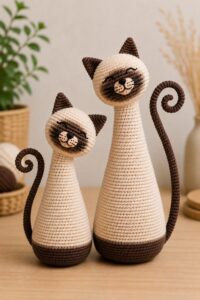 Siamese style amigurumi cat for beginners, crocheted with tilted head and spiral tail.